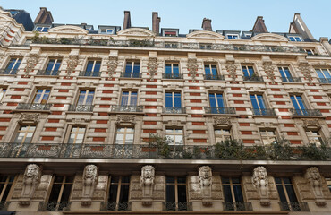 The facade of traditional French house with typical balconies and windows. Paris.