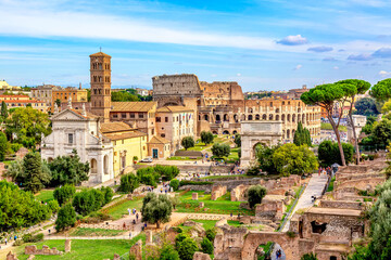 Fototapeta na wymiar Aerial panoramic cityscape view of the Roman Forum and Roman Colosseum in Rome, Italy. World famous landmarks in Italy during summer sunny day.