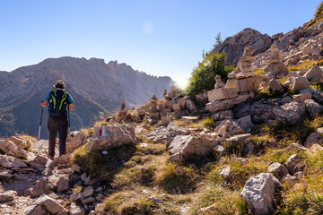 Fototapeta premium Active senior caucasian man hiking in mountains with backpack, enjoying his adventure. Carezza, Dolomites Alps, South Tyrol, Italy, Europe.