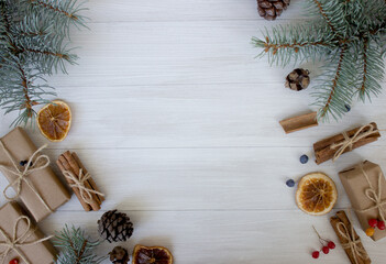 Christmas composition. Christmas gifts, pine cones, fir branches on white wooden background. 