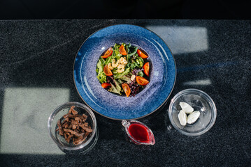 Prepare a delicious fresh salad of tomato greens, cheese, veal and cashew nuts. Delicious healthy food.