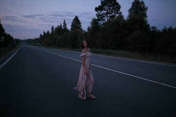 Girl on an empty highway. Girl on the road in the morning.