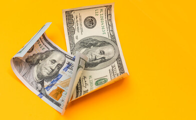 Single Hundred Dollar Bill Curled on yellow