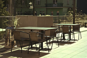 Fototapeta na wymiar Empty cafe tables toned green summer outside