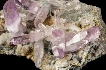 Macro mineral stone Amethyst crystals in rock on a black background