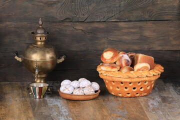 copper samovar and buns on wooden background