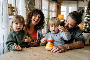 Fototapeta premium Family and childhood concept. Young parents spending time together with children at home.