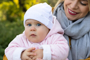 Happy beautiful mother spending time with her little baby girl in nature.