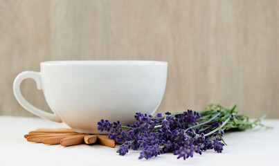 Cup of healthy hot lavender tea and lavender bouquet on a wooden table. Concept of a healthy...
