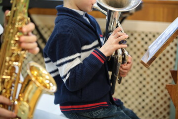Little boy playing the big trumpet in school orchestra.The concept of creative development of...