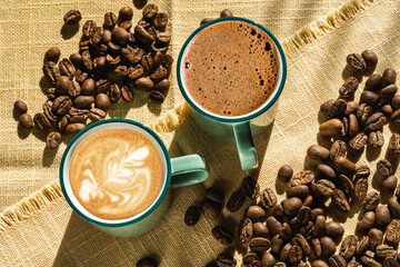 Cups of coffee and coffee beans,illuminated by sunlight .