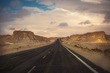 Fototapeta na wymiar The road leading through the Black and White Desert in Bahariya. Egypt