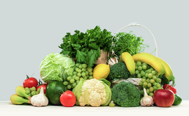 Fresh green vegetables in a basket on a wooden table. Banner with copy space. Green vegetarian diet or cuisine. Broccoli cabbage and celery. Grocery delivery or shopping online. Green diet