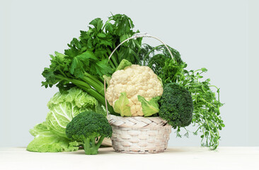 Fresh green vegetables in a basket on a wooden table. Banner with copy space. Green vegetarian diet...