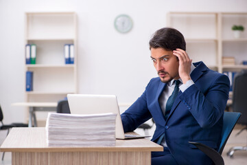 Fototapeta premium Young male employee and too much work in the office