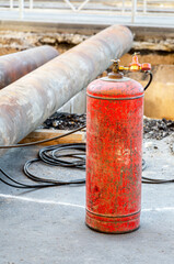 Red acetylene cylinder for gas cutting metal at a construction site