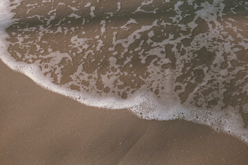The texture is soft sand on the sea surf line.