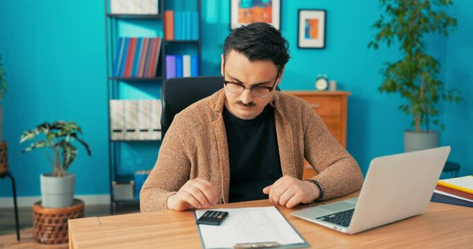 Accountant head of company employee of accounting office stay after working hours counts on calculator checks data and paper statistics, enters numbers into system determines salaries profits expenses