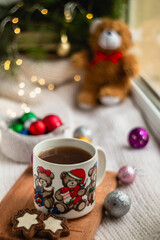 Christmas morning with a cup of hot tea with the image of bears on a blurred shiny background.