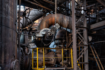 Lots of thick, dirty pipes. Fragments of metallurgical equipment