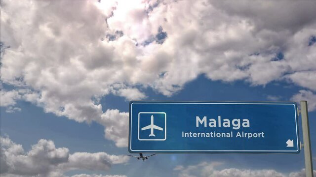 Jet plane landing in Malaga, Spain. City arrival with airport direction sign. Travel, business, tourism and airplane transport concept.