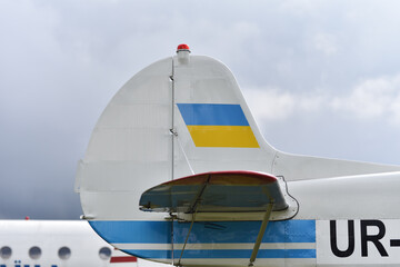 tail of short-haul passenger airplane with ukrainian flag in airport