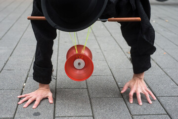 Closeup of man balacing on hands playing with diabolo in the street