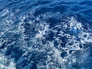 Aerial view to ocean waves. Blue water background