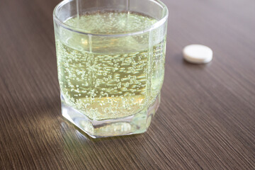 Aspirin or effervescent pill tablet sparkling bubbles in glass of water