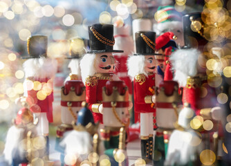 Nutcracker toys on shop shelf with blurred Xmas lights.