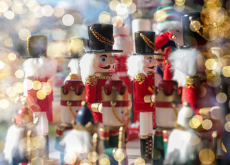 Naklejka premium Nutcracker toys on shop shelf with blurred Xmas lights.