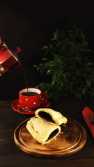 Breakfast with sweet chocolate sandwich-sized calzone  and coffee served on dark wooden table.