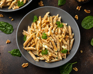 Whole Wheat Penne pasta with gorgonzola cheese sauce, spinach and walnut. Healthy food.
