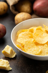 Potato Chips with cheese and onion in white bowl on rustic background
