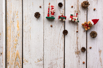 Christmas background with decoration like pine cones an christmas figures on a light, rustic wooden background in vintage style