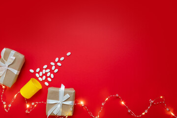 medical layout on a red background with a beautiful garland of a Christmas tree made of pills and gifts. merry christmas concept for doctors and medical clinics