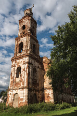 Fototapeta premium Ruins of a red brick of an ancient church against a blue sky with clouds. Belarusian architecture.