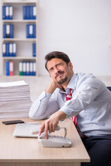 Young male employee sitting at workplace