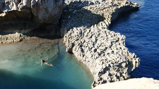 Woman in bikini relax in water with fins at Inland sea, Gozo