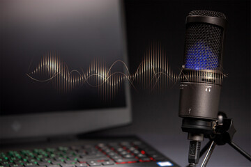Micrófono de podcast emitiendo ondas de radio coloristas con portatil de fondo