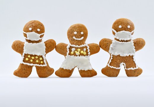 Cute gingerbread man, woman and child decorated with icing, white background. Creative concept in coronavirus (COVID-19) time, greeting card