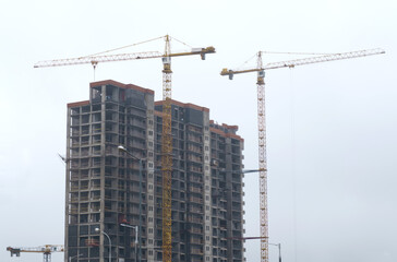 Tower cranes at the construction site of a multi-storey building.