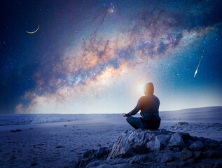 person meditating at night under the Milky Way Moon and shooting star
