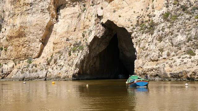 Boat with tourists come outside cave at Inland sea, Gozo