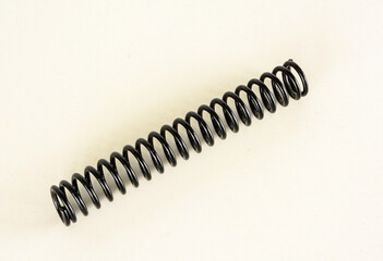 Top view of a black plastic coil spring isolated on a white background
