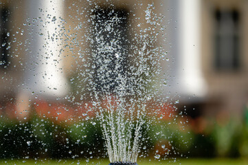 fountain splash close-up on a defocused background of an old manor, selective focus