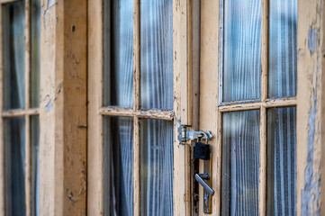 vintage wooden door with glass and peeled paint, peeled paint and wooden texture, door with padlock
