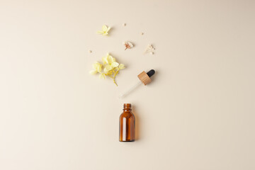 Minimal composition with cosmetic bottle with flowers on pastel beige background. Flat lay, copy space