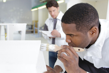 young man painting at building site