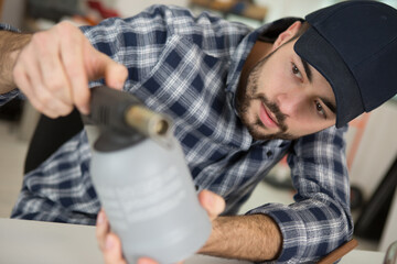 man unscrews the valve from the gas bottle